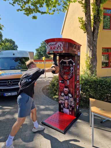 Ein Jugendlicher schlägt auf einen Boxautomaten im Freien.