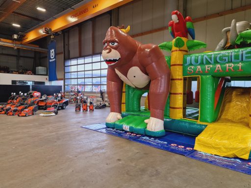 Buntes aufblasbares Spielgerät mit Gorilla und Papagei im Indoor-Spielbereich.