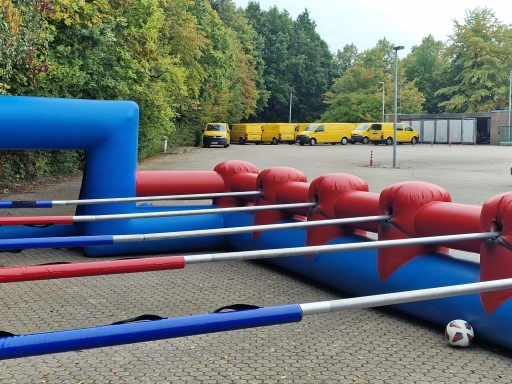 Aufblasbares Tischfußballspiel im Freien mit roten und blauen Stangen.