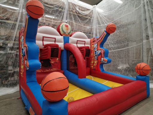 Bouncy Castle mit Basketballkörben und großen, orangefarbenen Bällen.