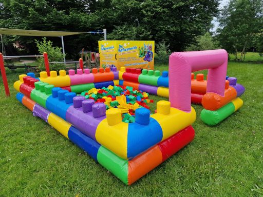 Buntes Hüpfburg-Spielplatz mit großen Bausteinen in verschiedenen Farben.