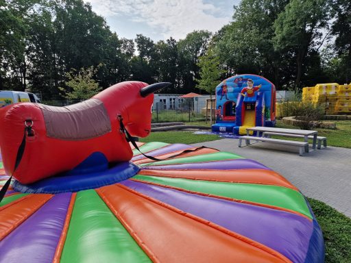 Bunte Hüpfburg und ein großer, roter Spielplatz mit buntem Mistral-Gemälde.