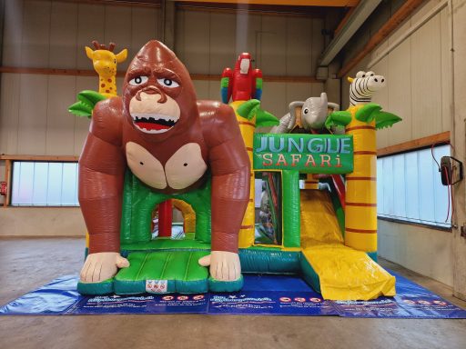 Bunte Hüpfburg mit einem großen Gorillas und anderen Tierfiguren, Thema Dschungel.