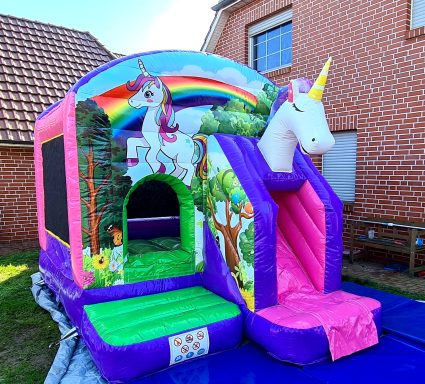 Luftspielgerät in Regenbogenfarben mit einem Einhorn-Motiv und Rutsche.