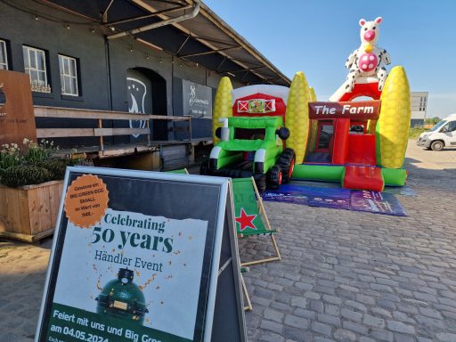 Luftige Hüpfburg in Form eines Traktors mit Rutsche und Spielbereich für Kinder.